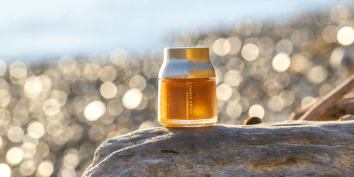 Manuka Honey Single Origin Pohuenui MGO 856+ jar of honey on a rock with a blurred natural background.