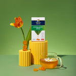 Mánuka Health honey drops with a cup of tea and a tulip on a green background