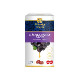 A box of Mânuka Health Mânuka Honey Drops in blackcurrant flavour, featuring a white and purple design with an illustration of blackcurrant grapes and a honey drop.