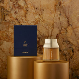 Manuka Honey Pinnacle Harvest MGO 1600+. Decorative vase and box on gold stands against a textured stone wall.
